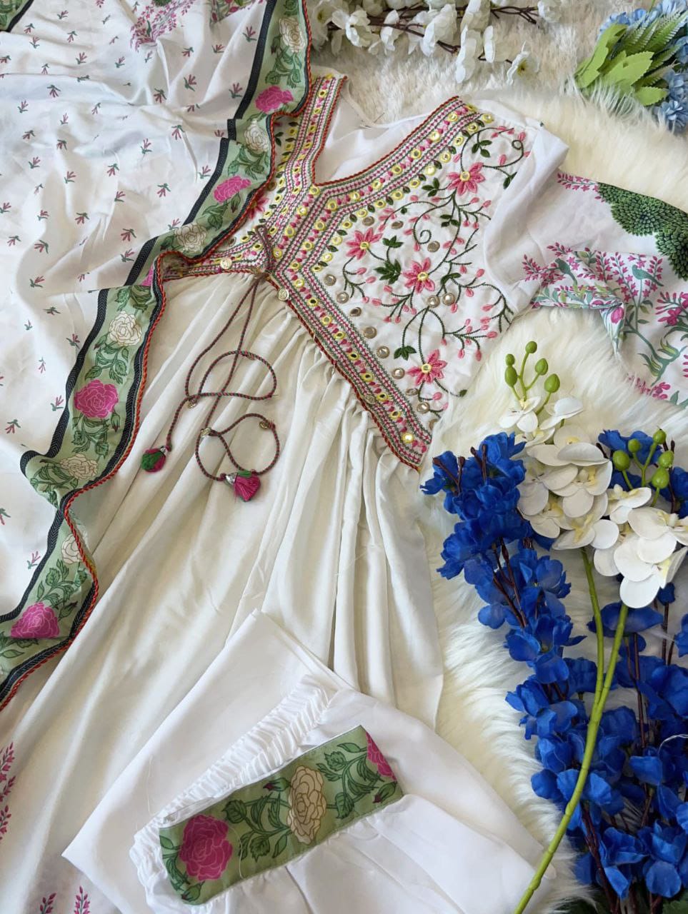 Featuring beautiful MUSLIN ALIA CUT Suit Set which is beautifully decorated with intricate hand embroidery, Zari weaving and prints. It is paired with matching pants and lace dupatta | White - Swaraas